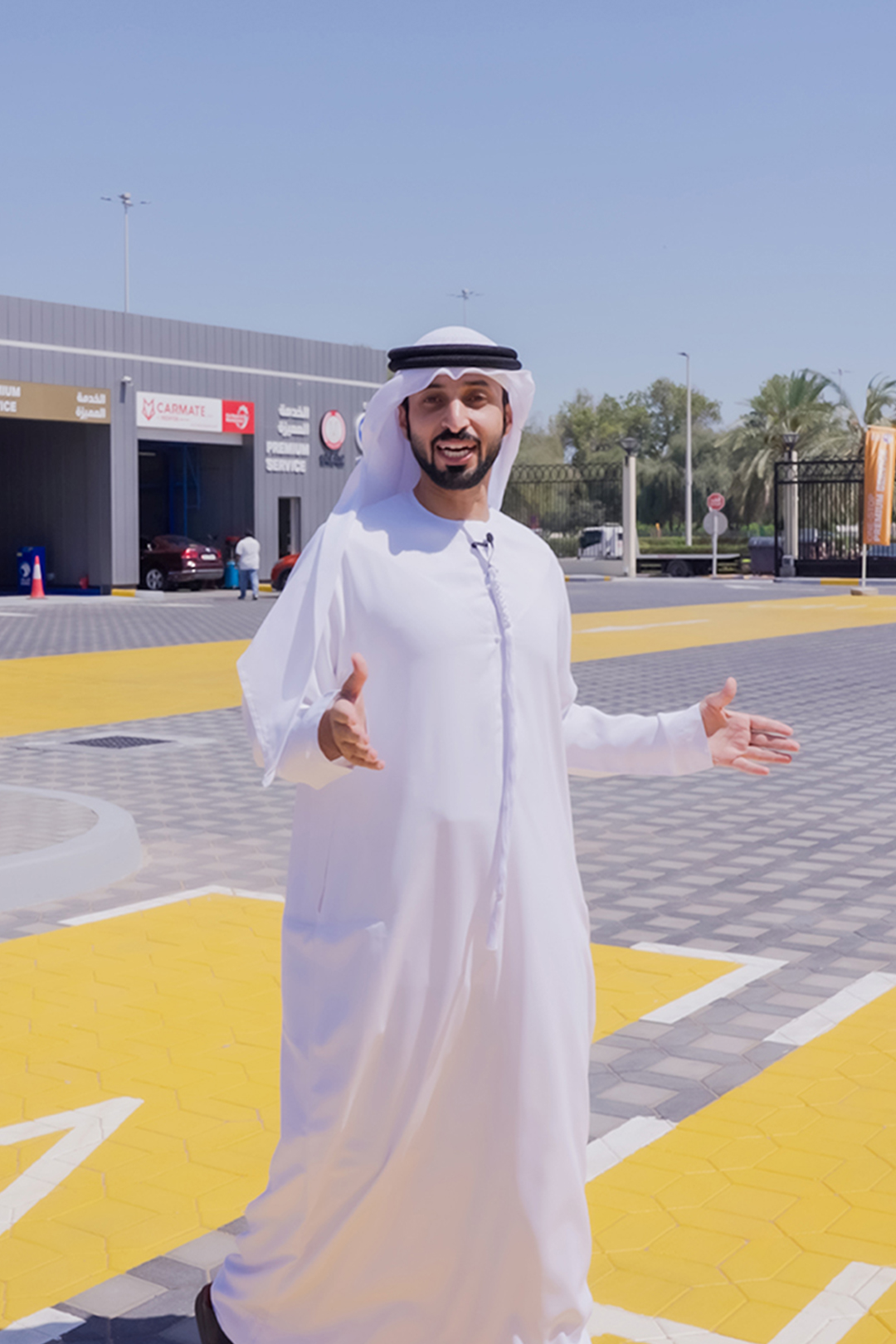 Emirati influencer standing at ADNOC service station, engaging with camera and showcasing modern Emirati lifestyle against the backdrop of the UAE's leading energy brand.